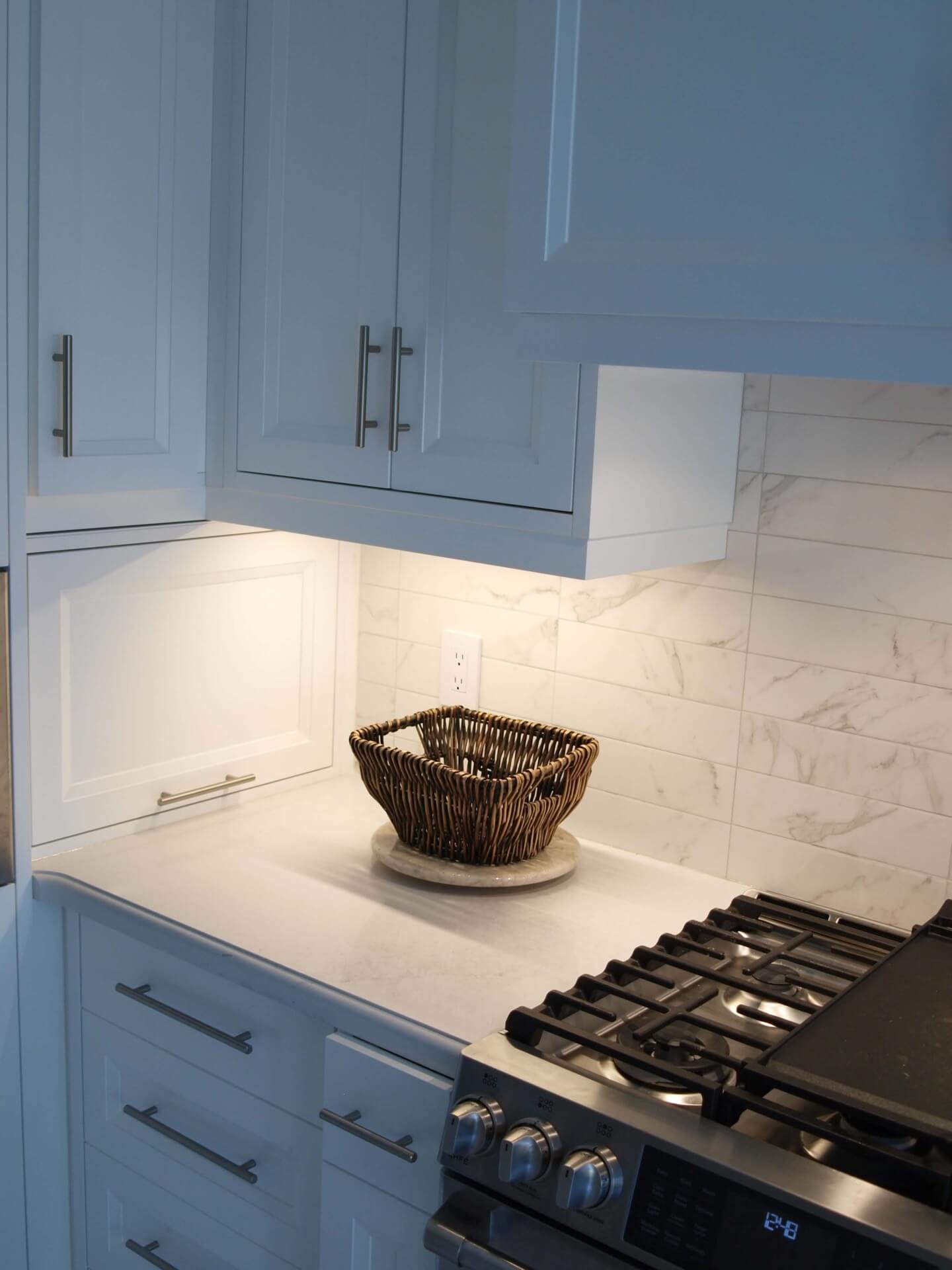 Kitchen LED under-cabinet lighting illuminating a counter and backsplash