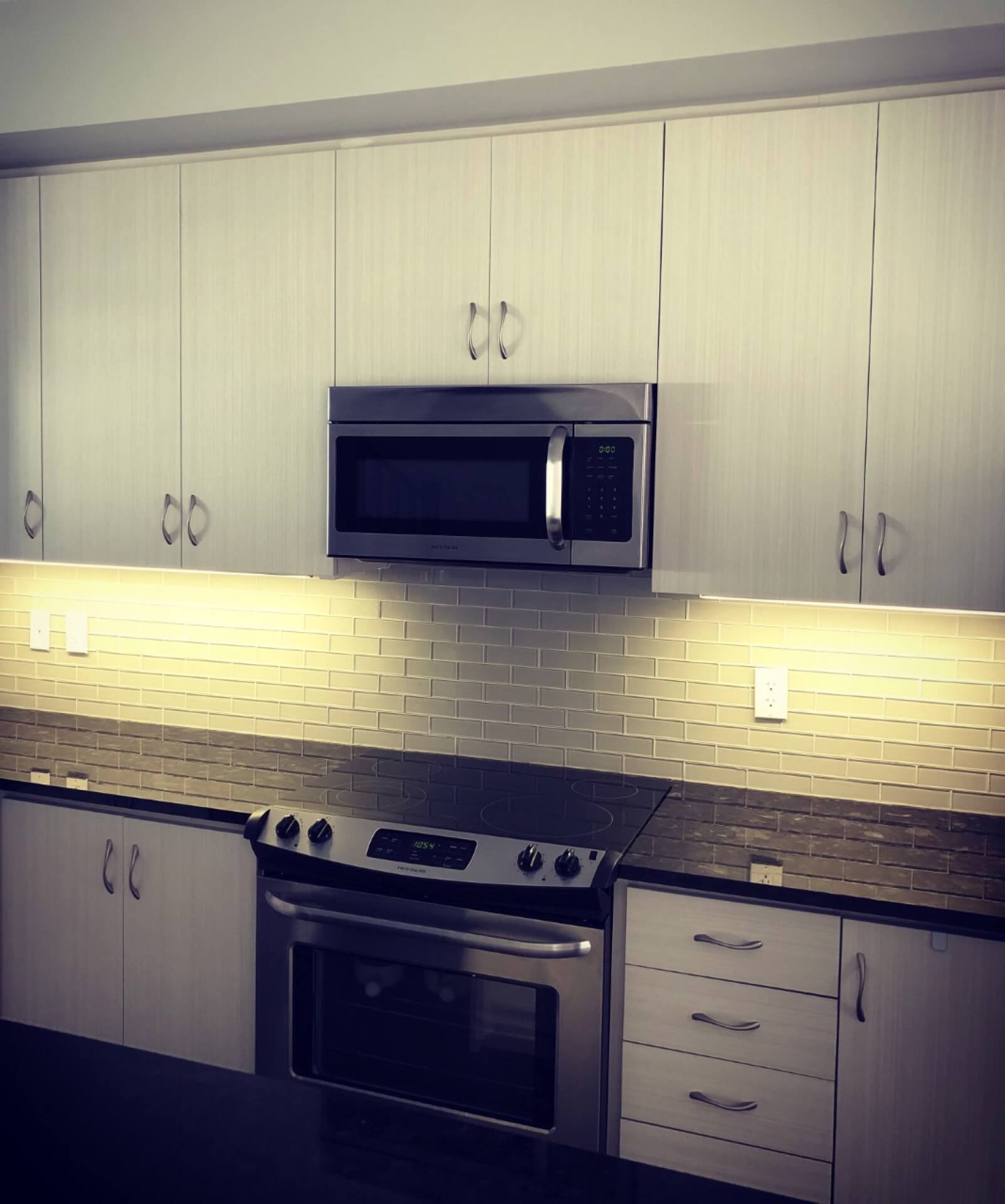 Under-cabinet lighting detail over a bright kitchen countertop