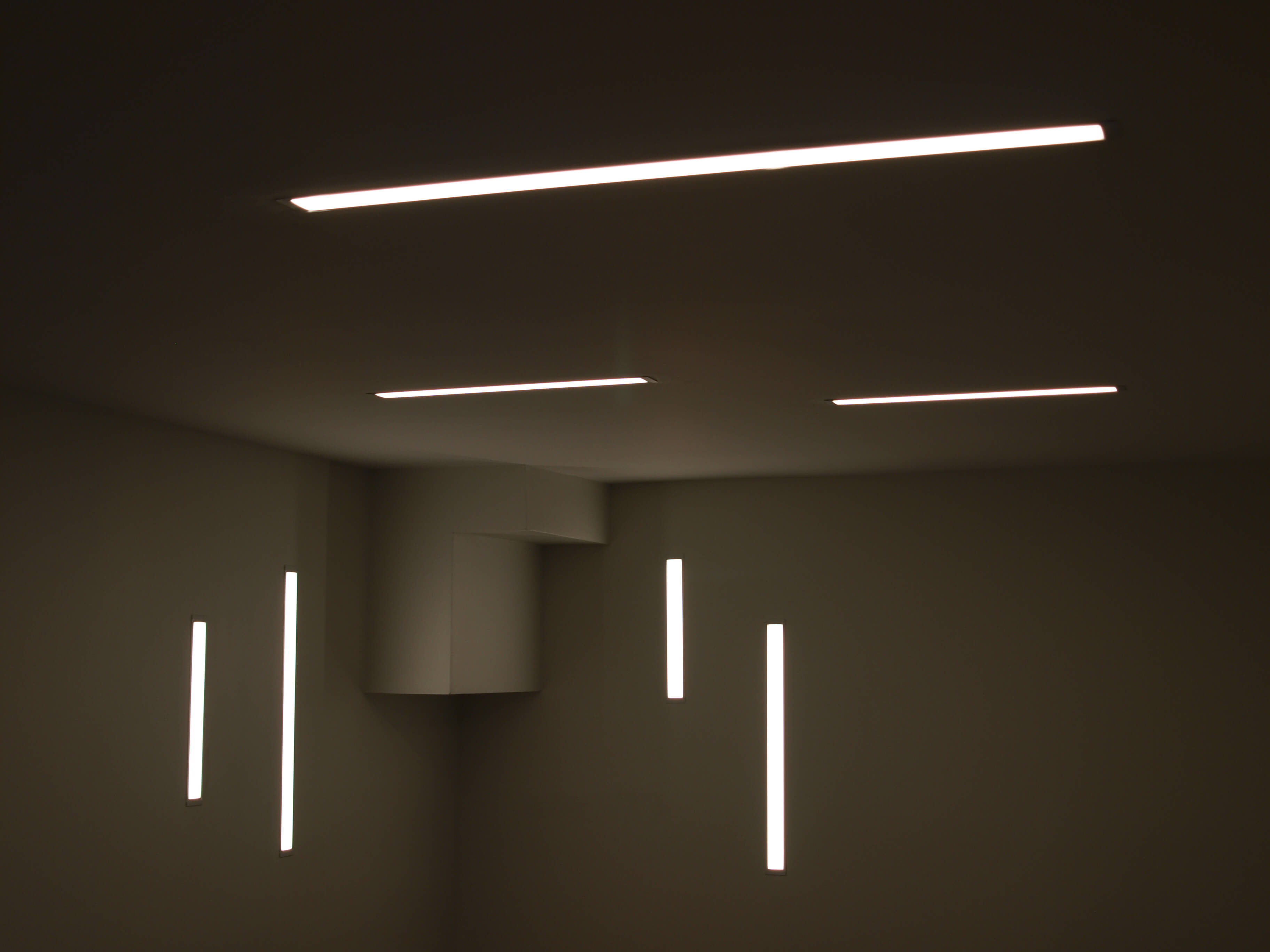 Custom recessed linear LED lighting in a modern basement office