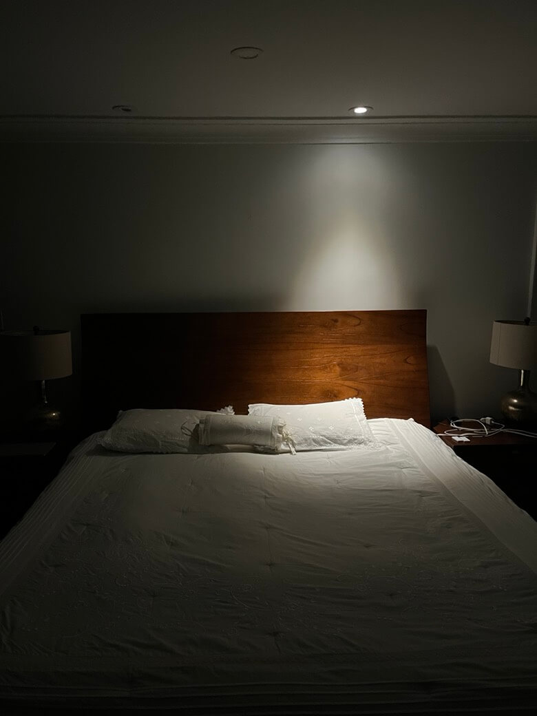 Integrated bedroom reading lighting above a bed