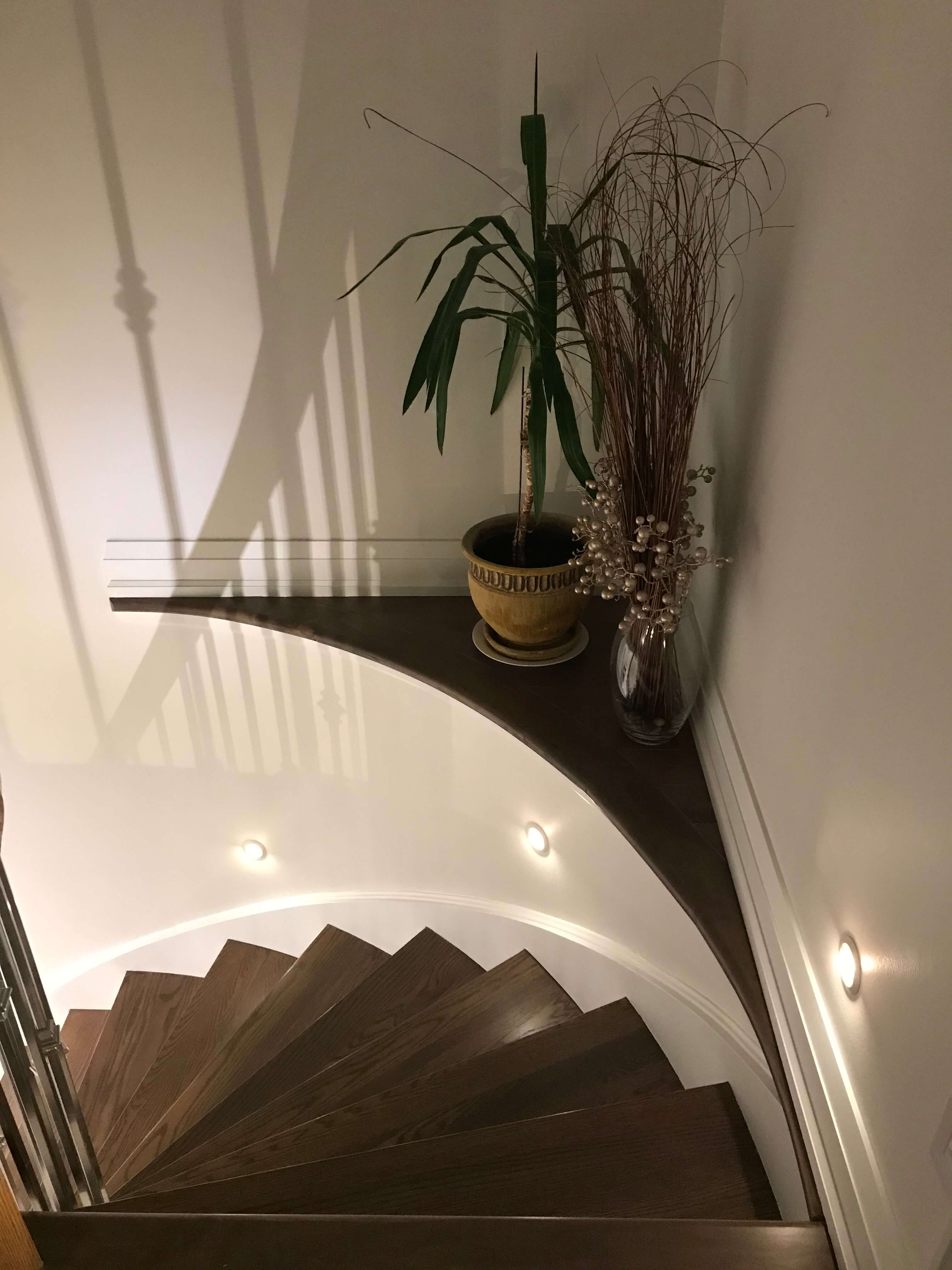 Residential staircase with round recessed wall lighting