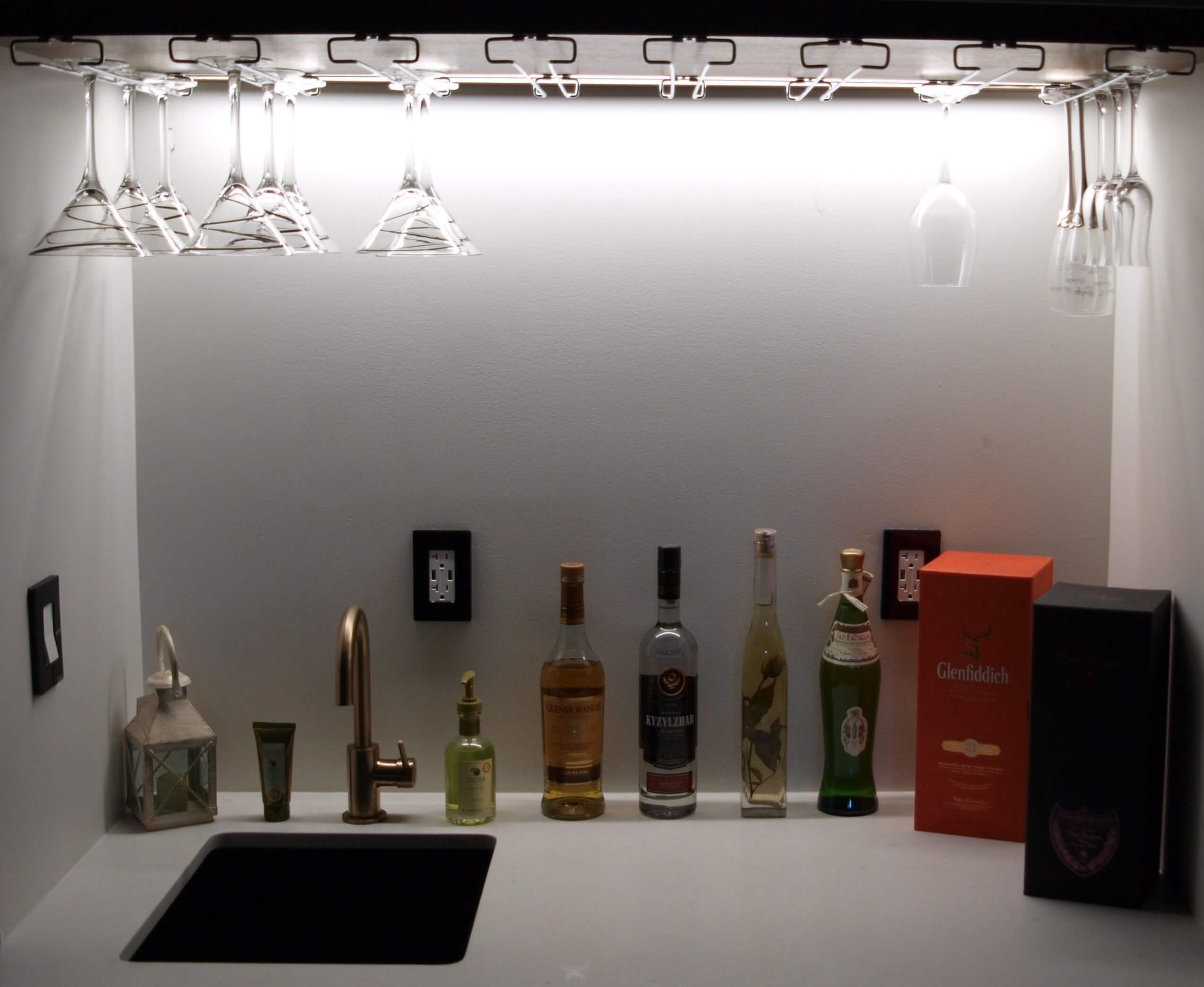 Basement bar shelf lighting with glasses and bottles