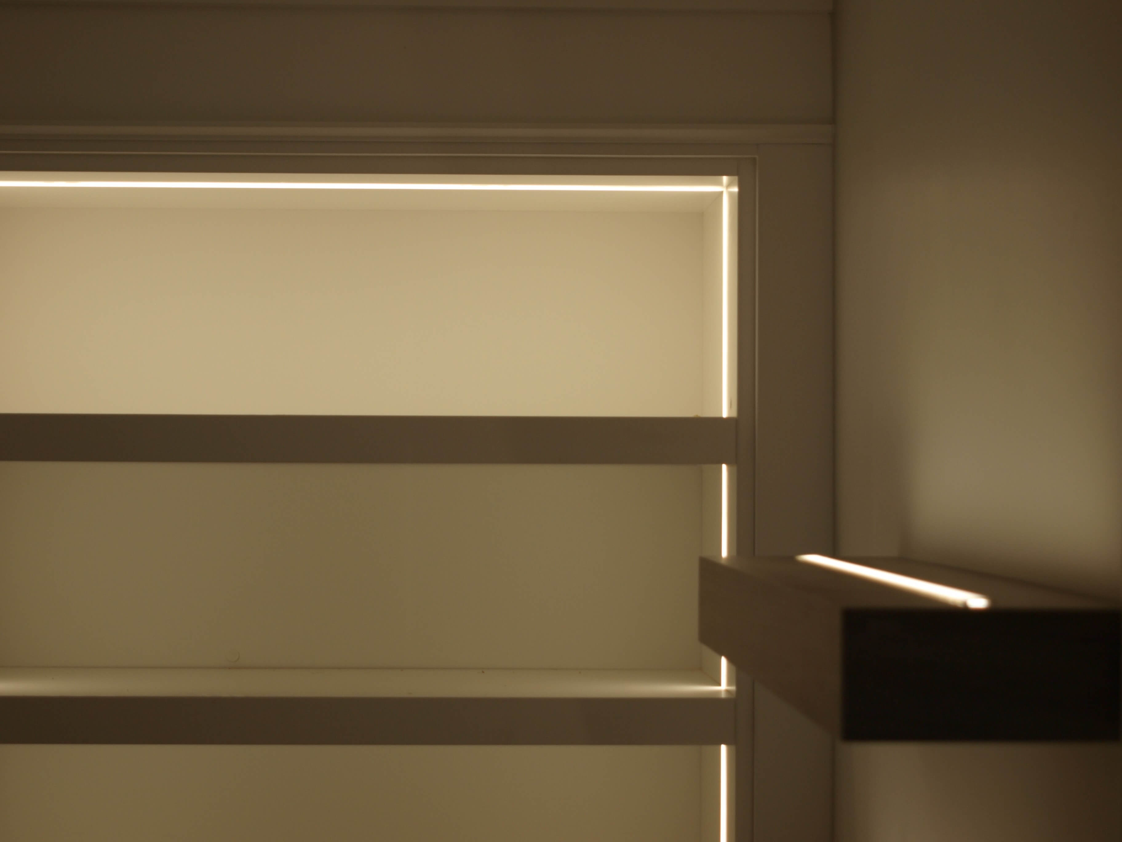 Upper shelf lighting detail in custom home office millwork